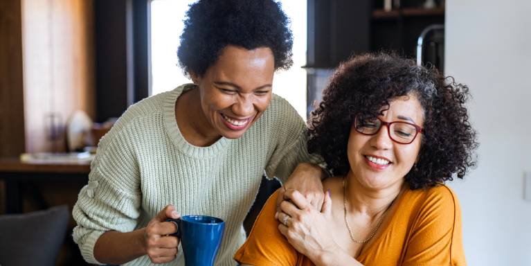 Two women smiling looking at laptop