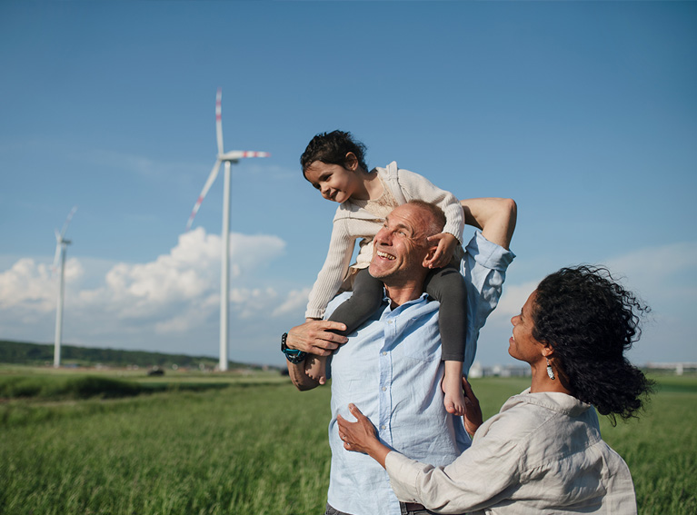 Family standing in front of a wind farm